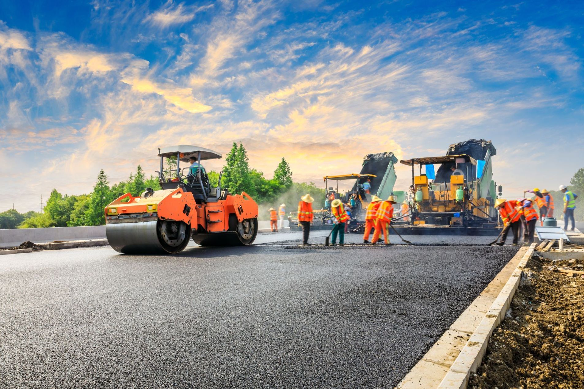 A group of construction workers are working on a road under construction.