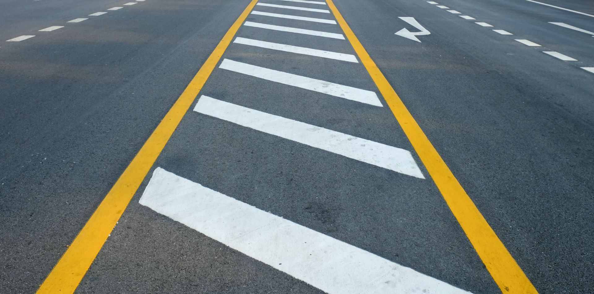 A close up of a road with yellow and white stripes and the letter z on it