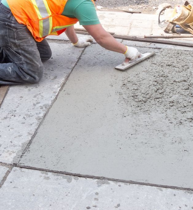 A group of construction workers are working on a road under construction.