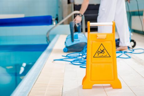 man cleaning the swimming pool tiles
