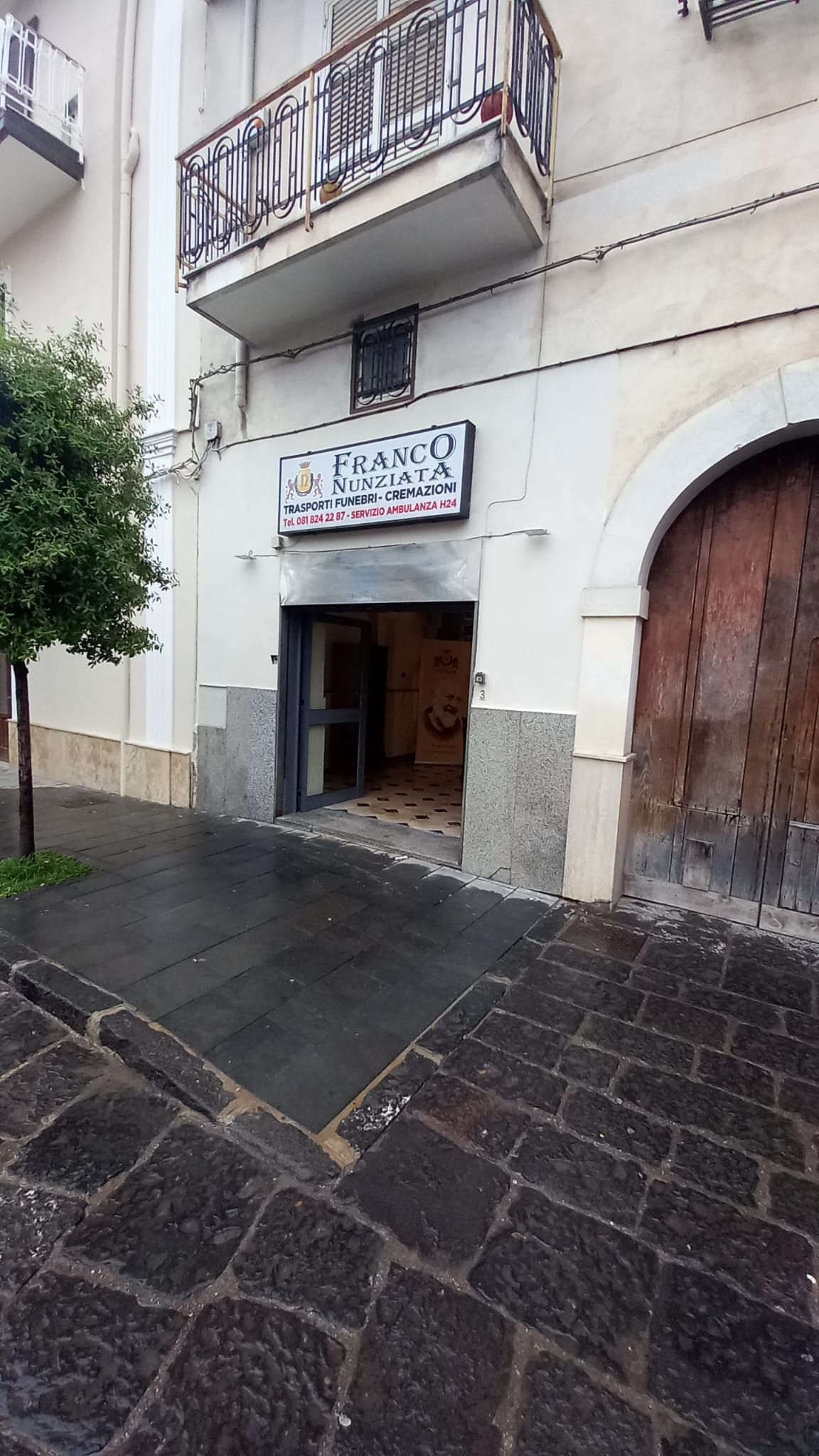 Un edificio con un balcone e un cartello sopra