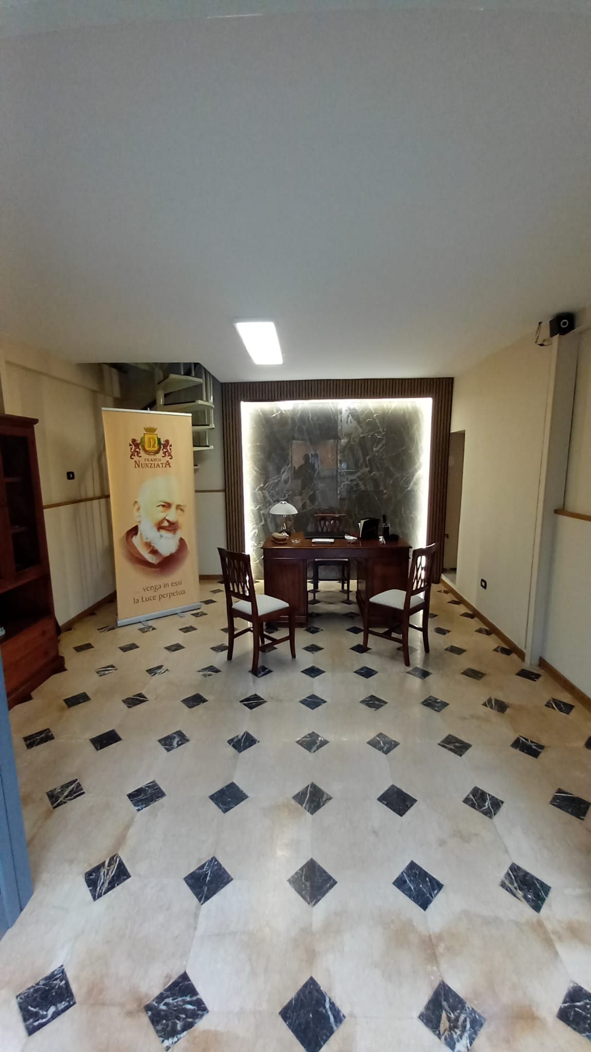 Una stanza con un tavolo, delle sedie e un pavimento a scacchi.