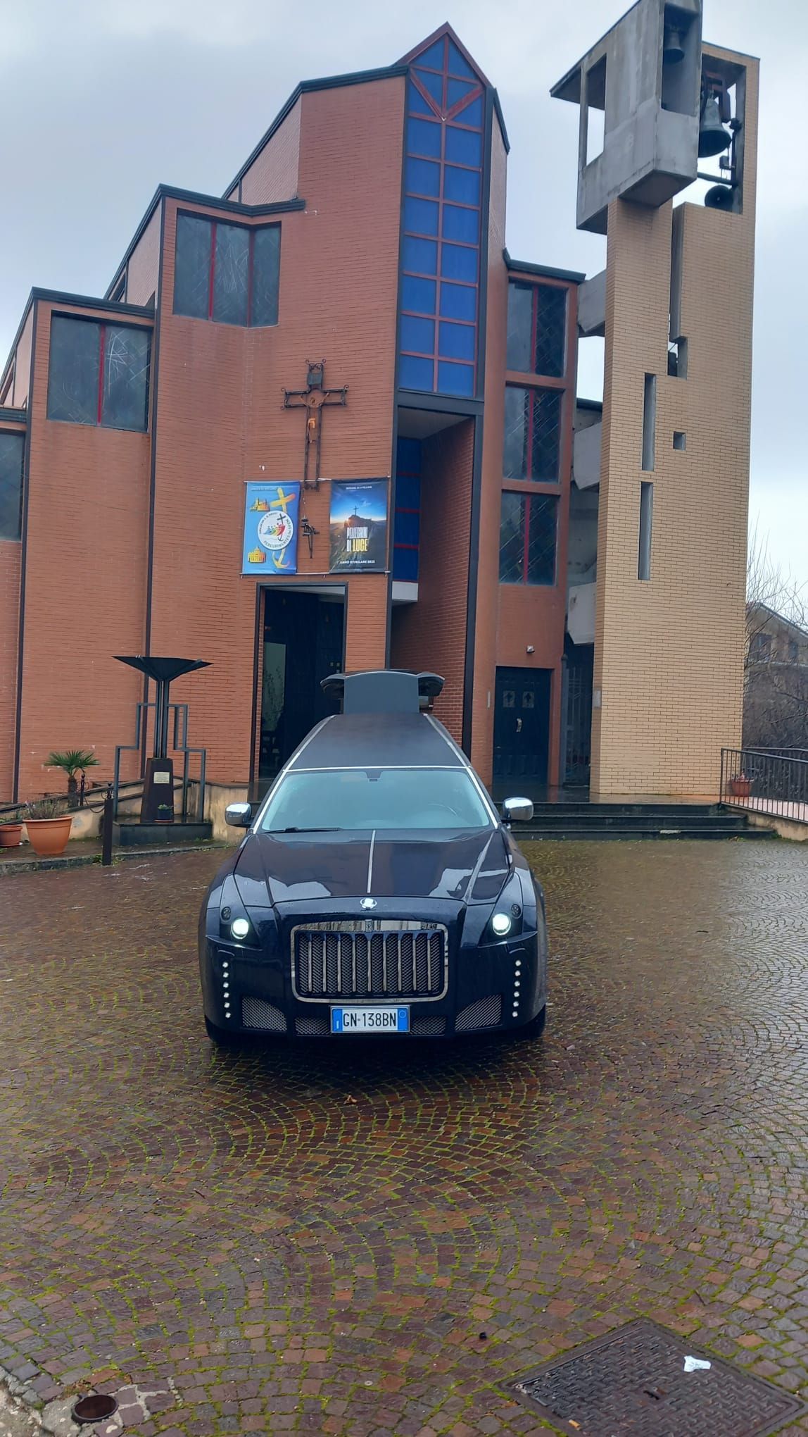 Un'auto argentata è parcheggiata davanti a una chiesa.