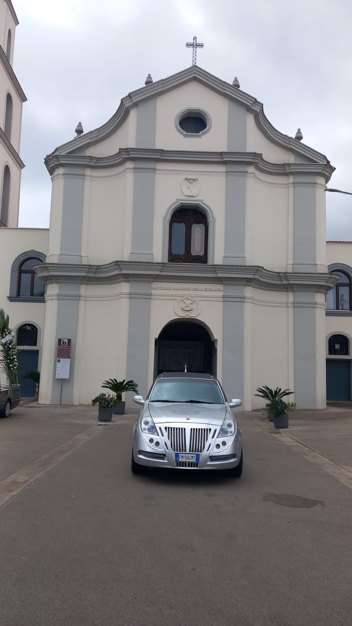 Un'auto argentata è parcheggiata davanti a una chiesa.