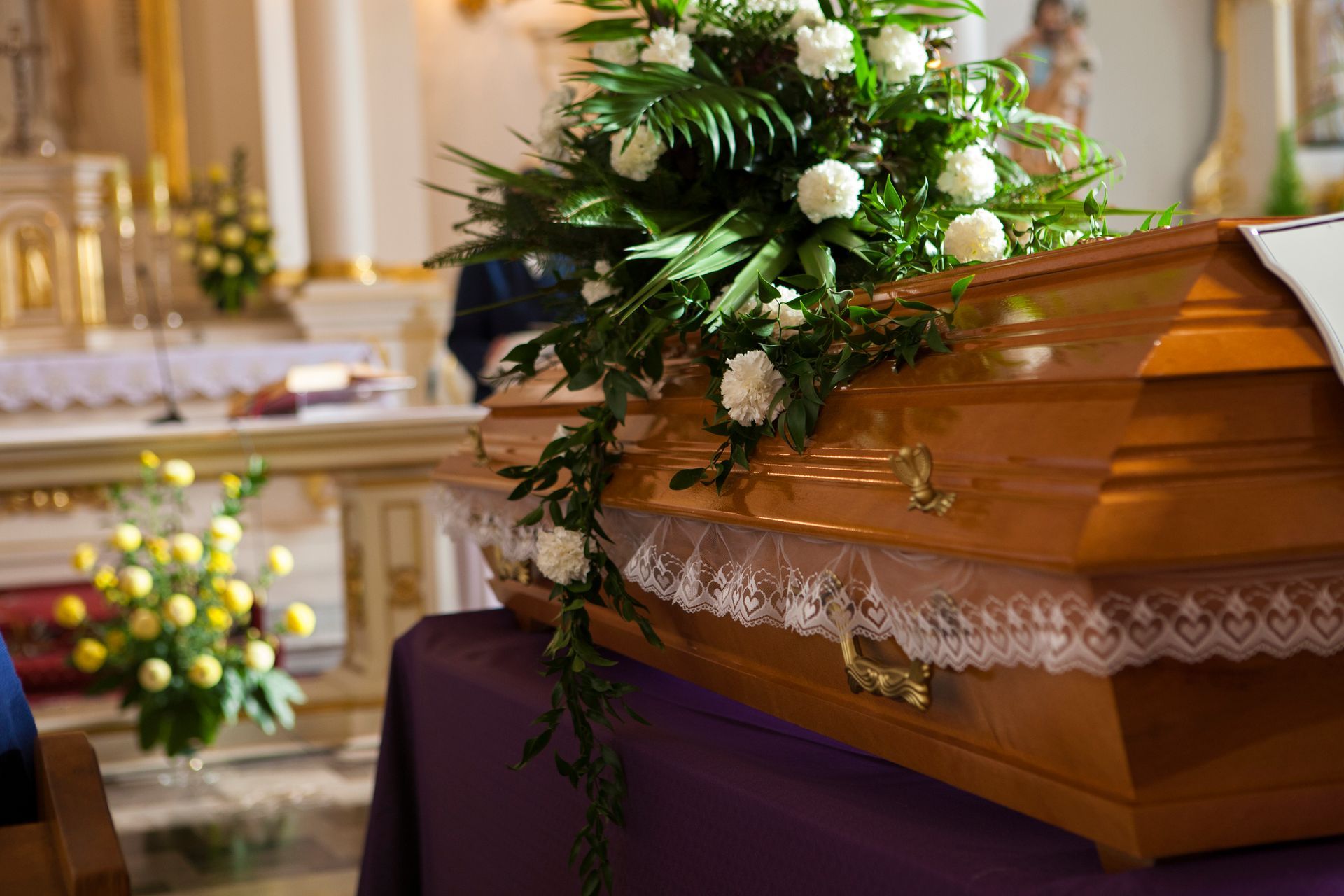 Una bara di legno è appoggiata su un tavolo in una chiesa.