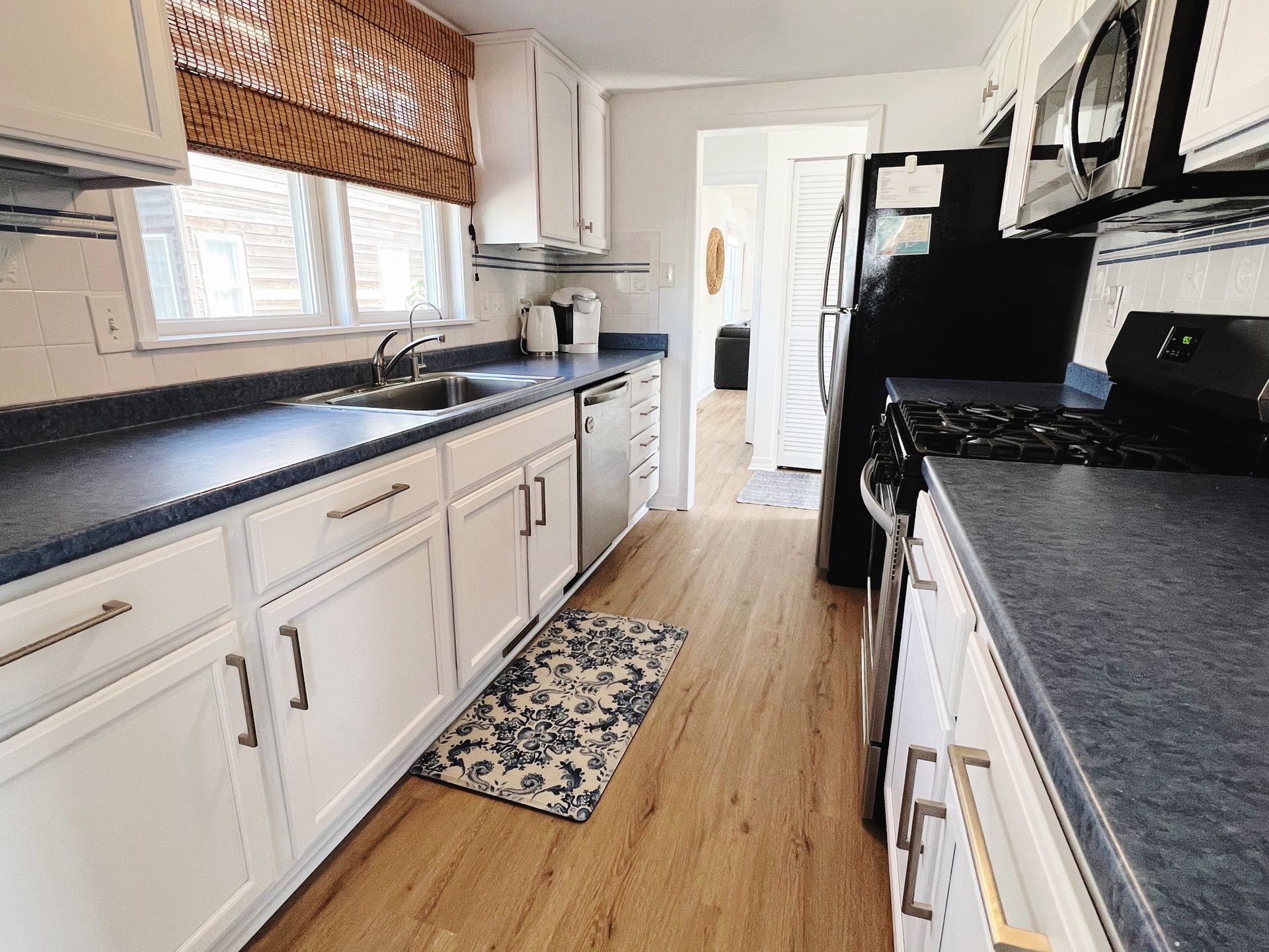 A kitchen with white cabinets and black counter tops