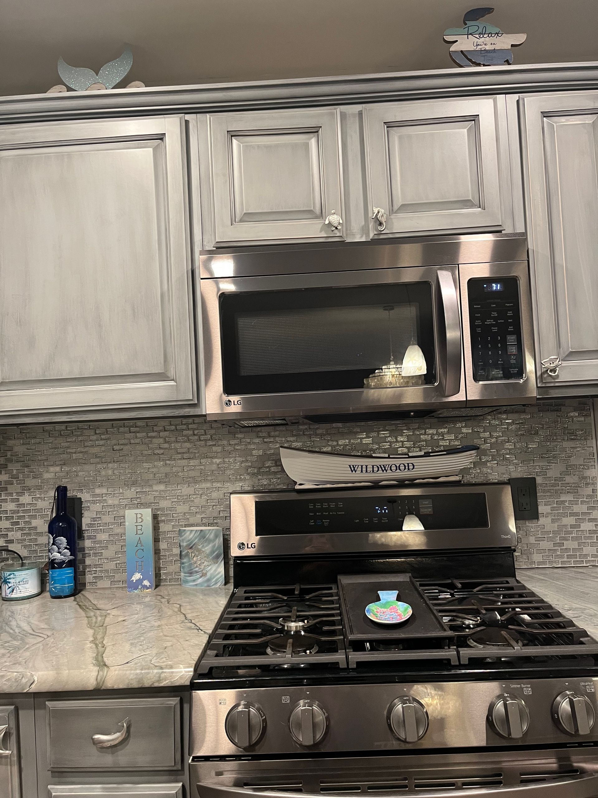 A kitchen with a stove , microwave , and cabinets.
