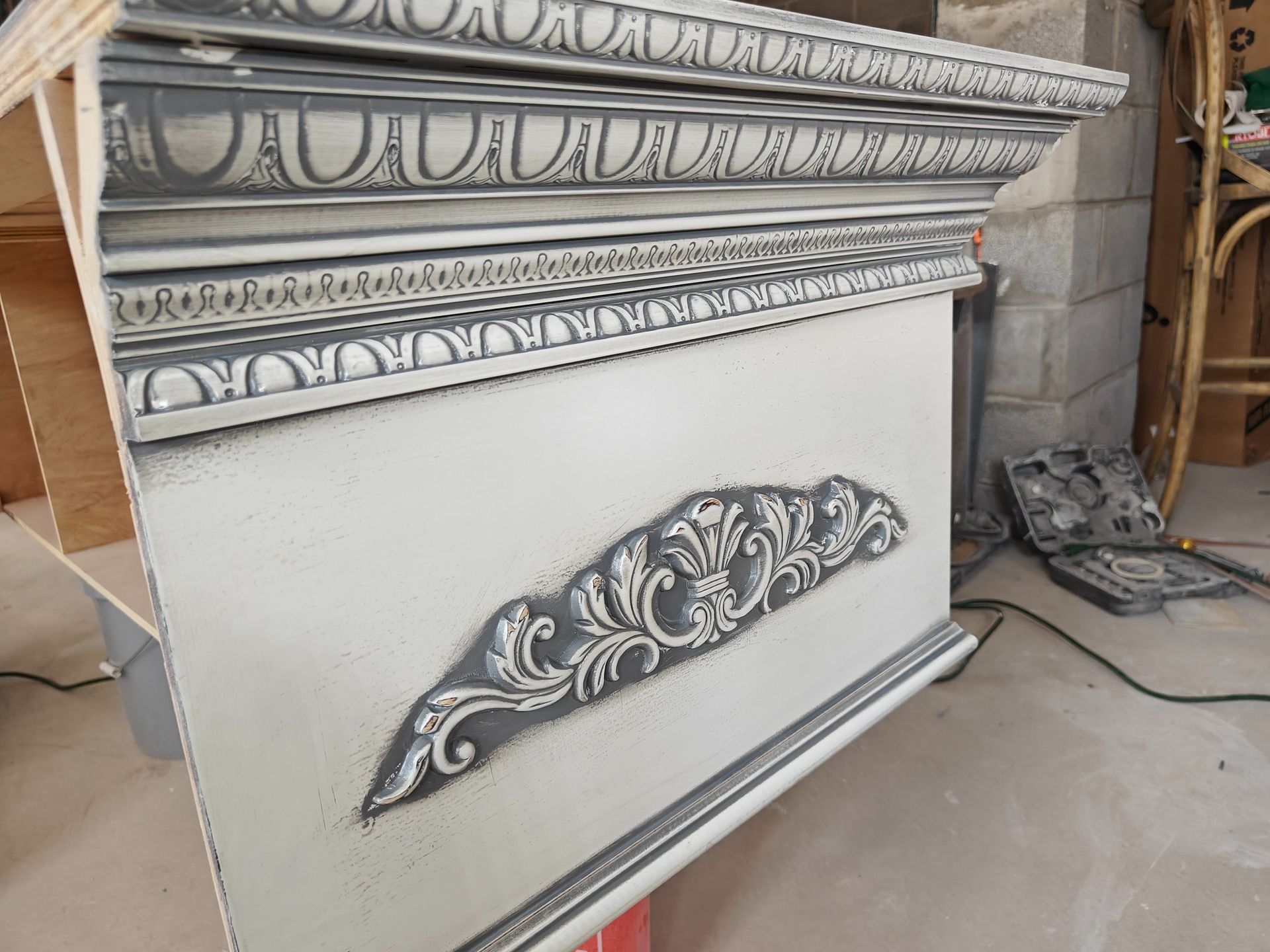 A white piece of furniture with a gray trim is sitting on a table.