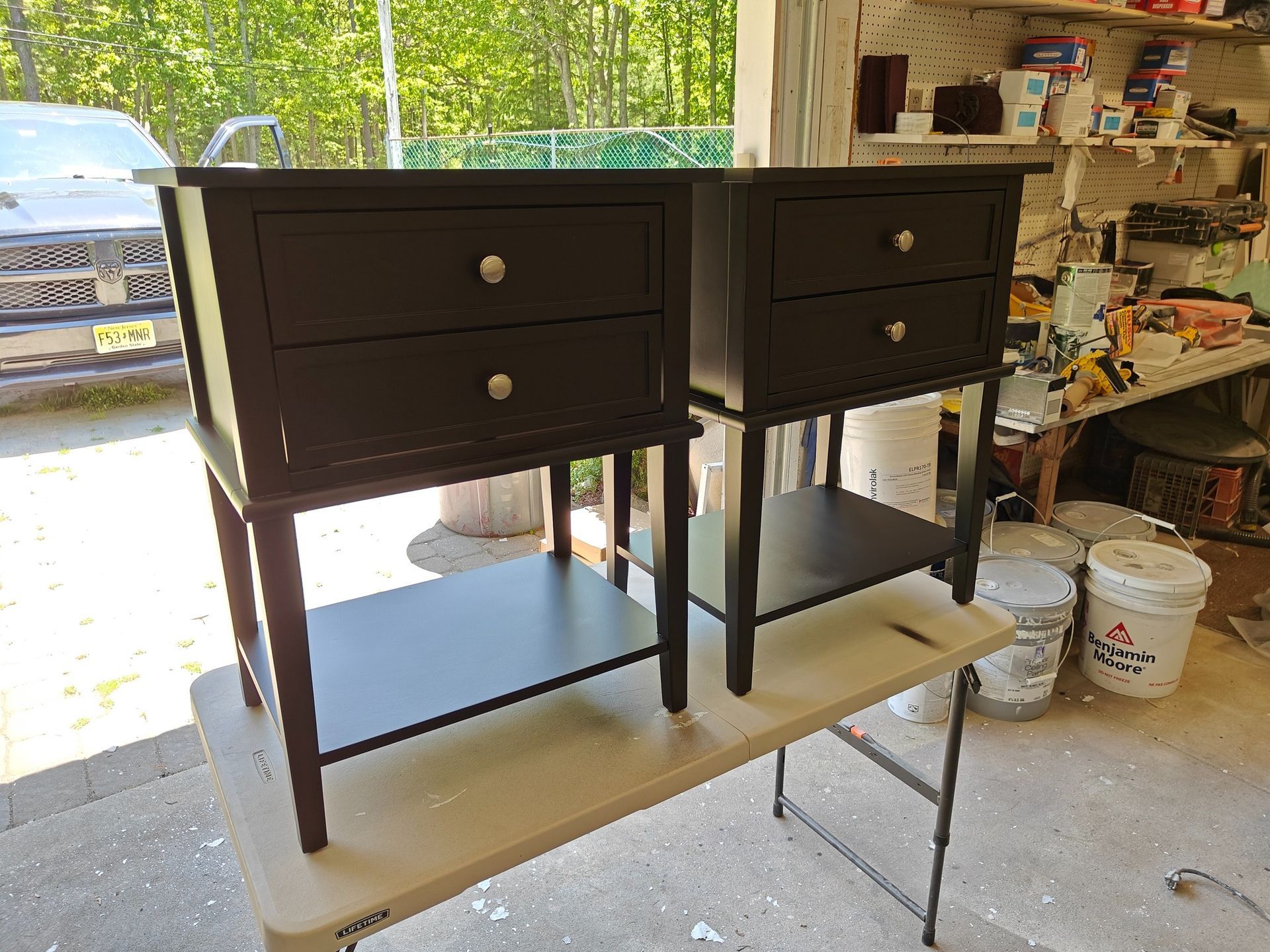 Two black nightstands are sitting on a table in a garage.