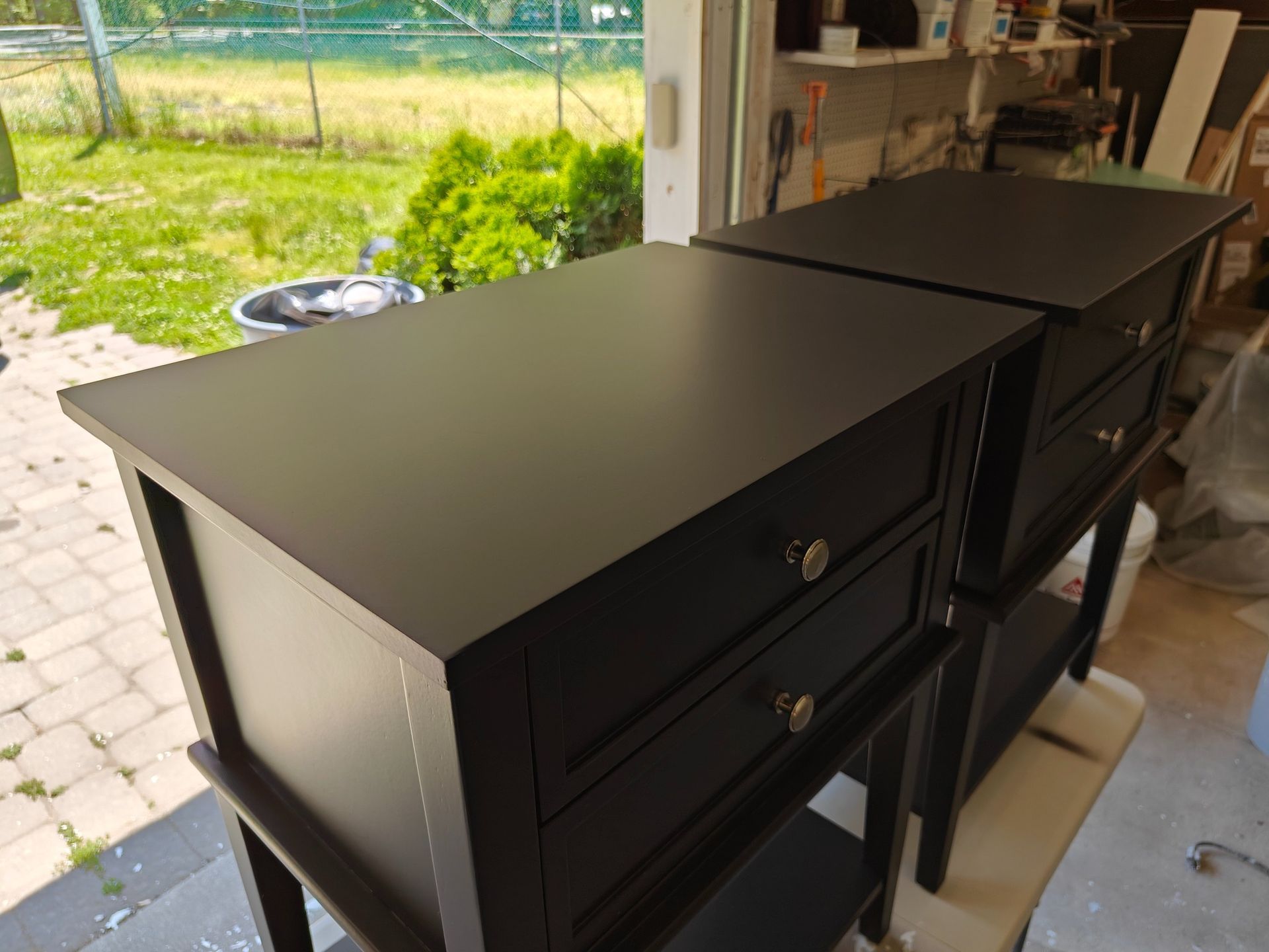 Two black nightstands are sitting next to each other on a table.