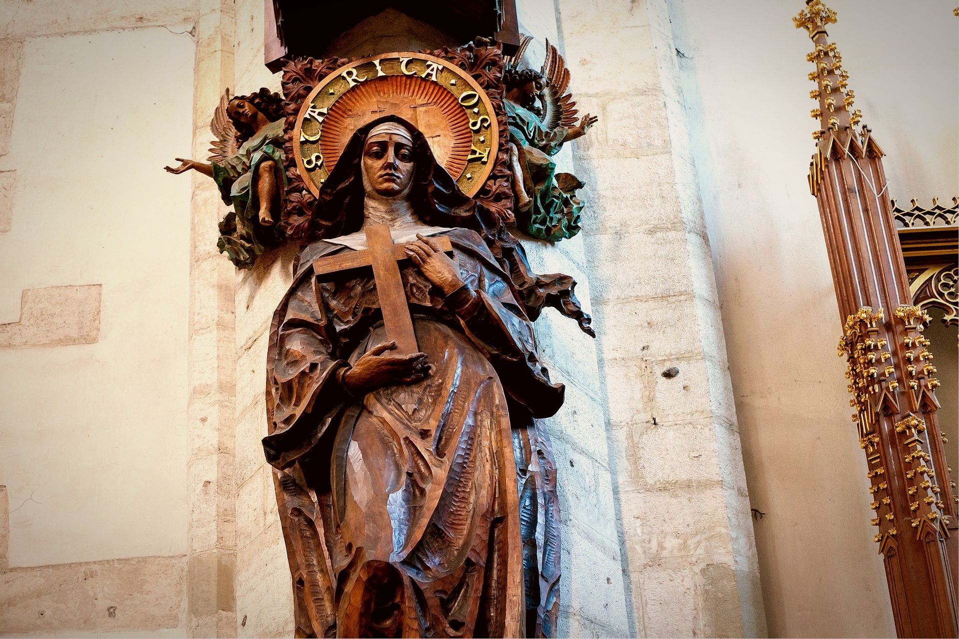 A statue of a woman holding a cross in a church