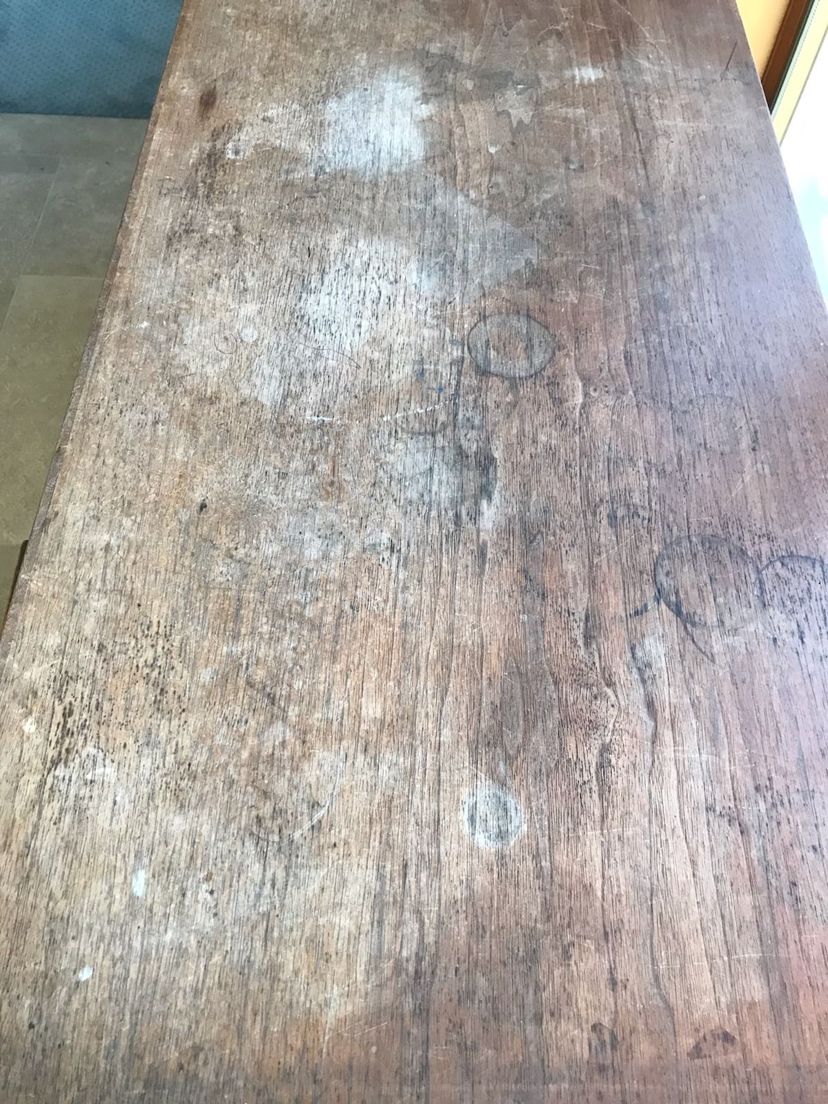 A close up of a wooden table with white spots on it.