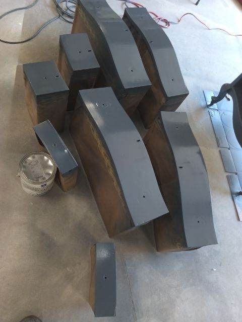 A bunch of metal pieces are sitting on the floor