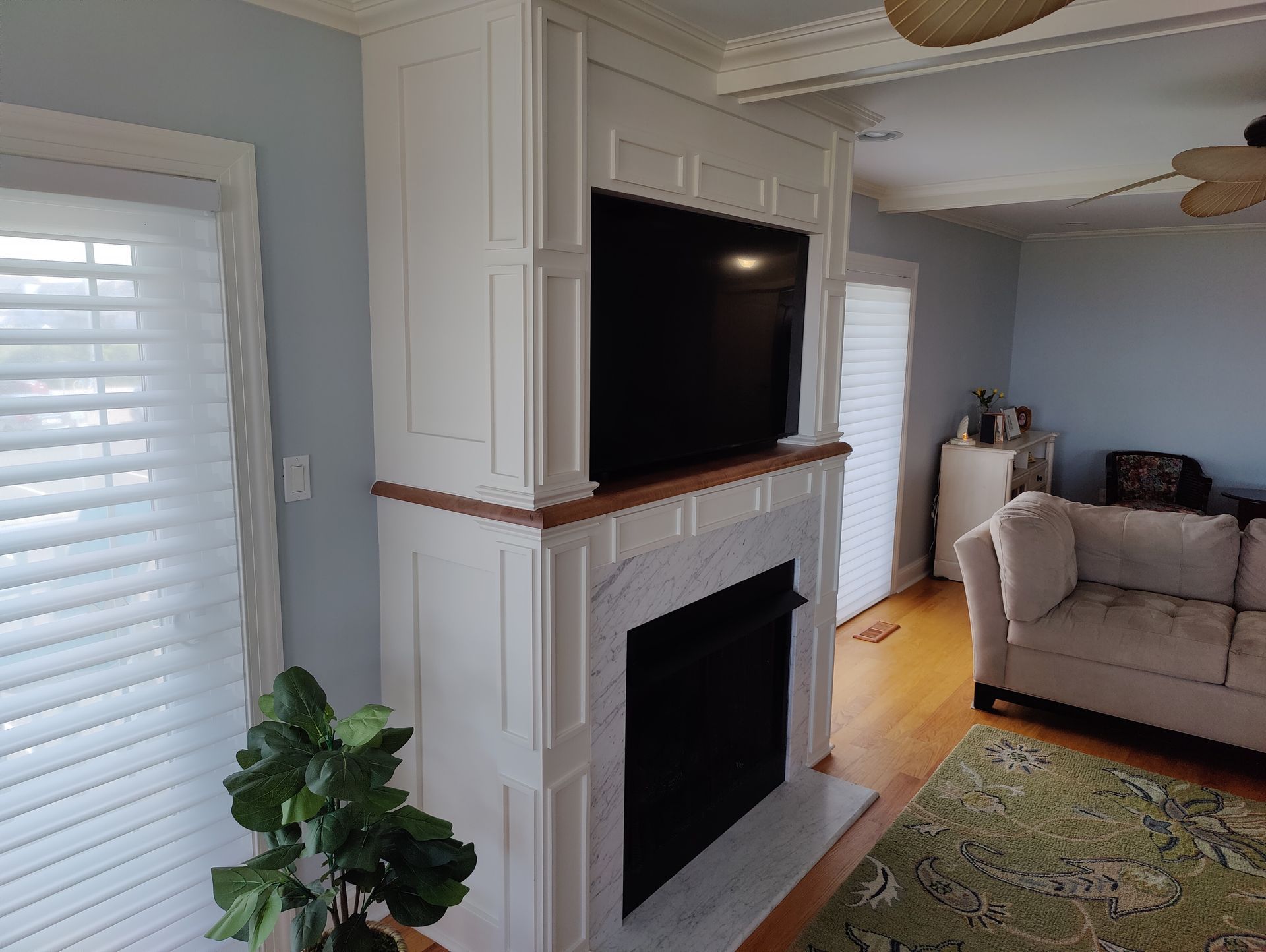 A living room with a fireplace , couch , and television.