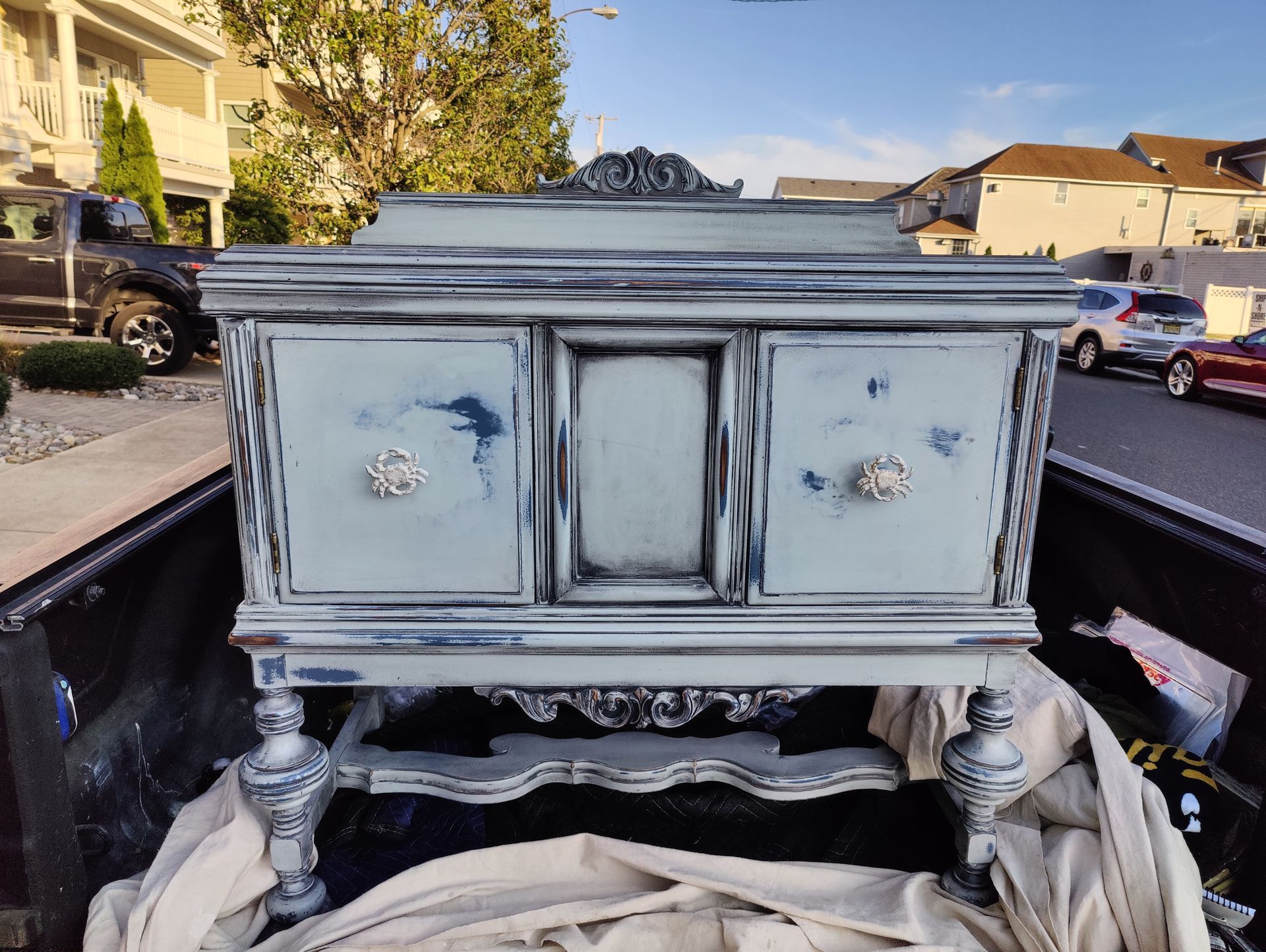 A small dresser is sitting in the back of a truck.