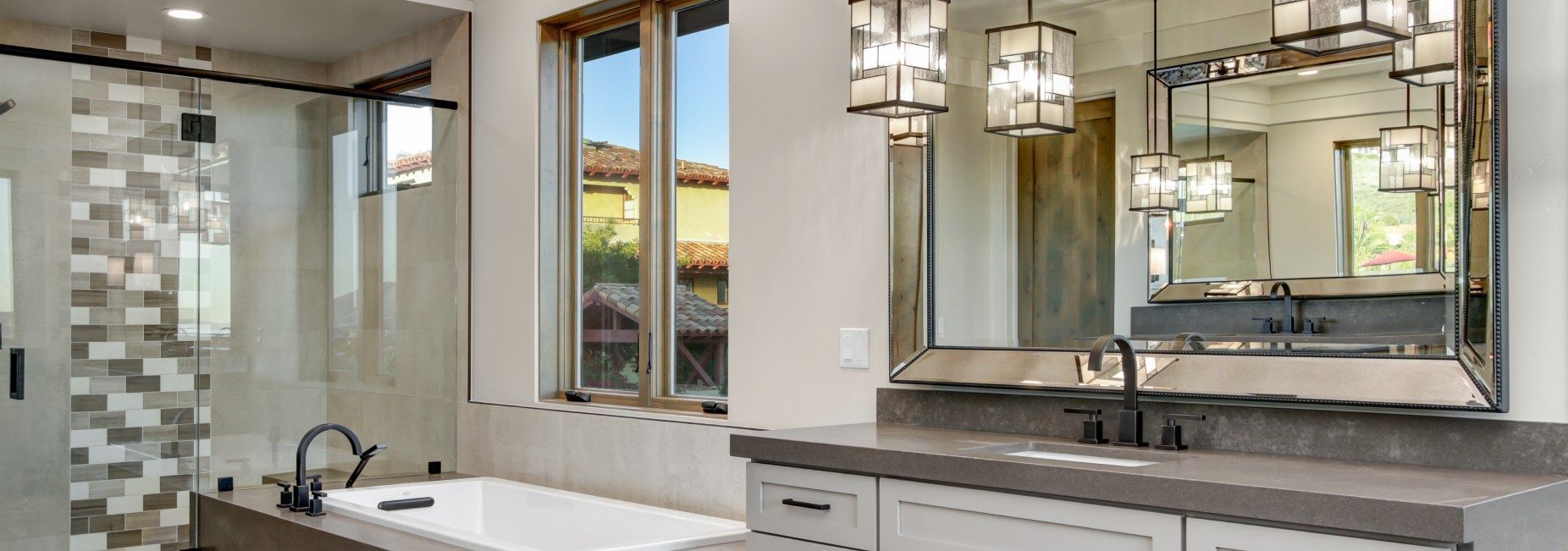 A bathroom with a tub , sink , mirror and shower.