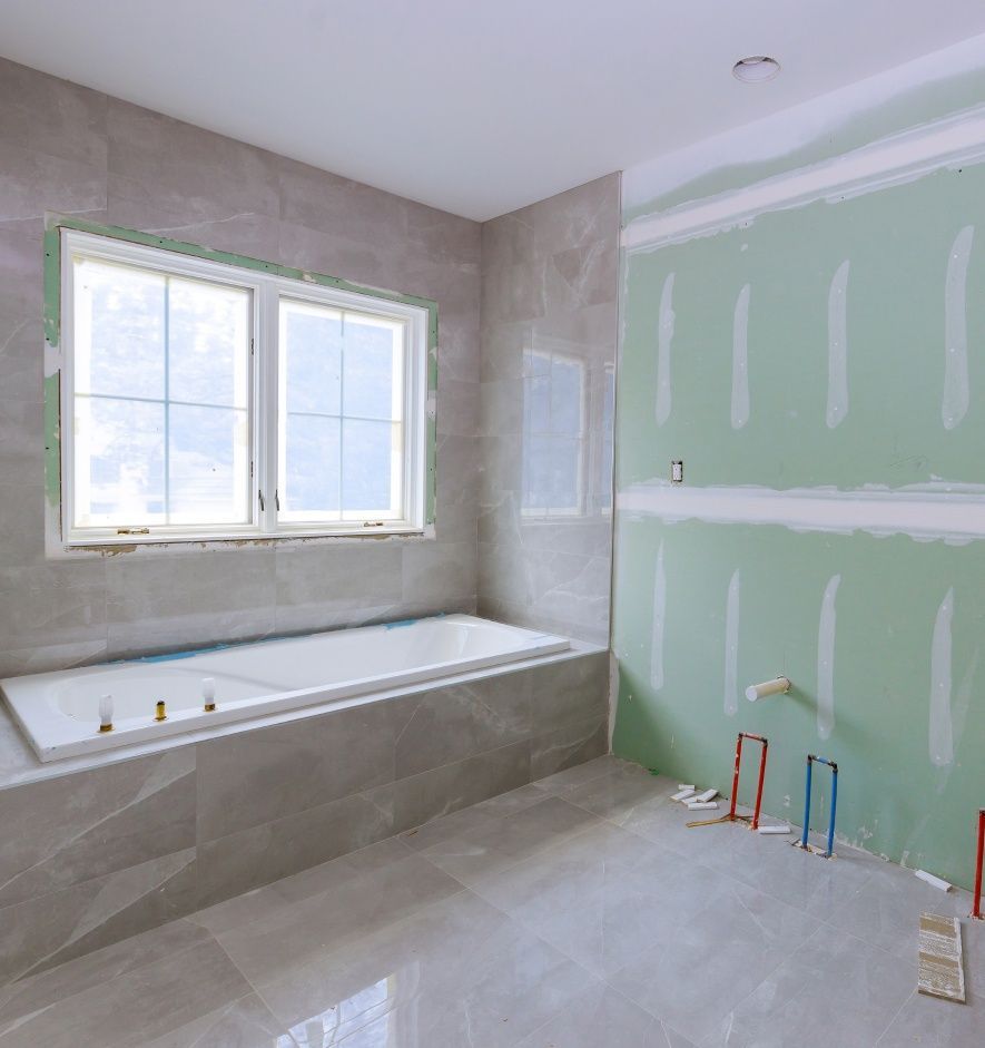 A bathroom under construction with a bathtub and a window.