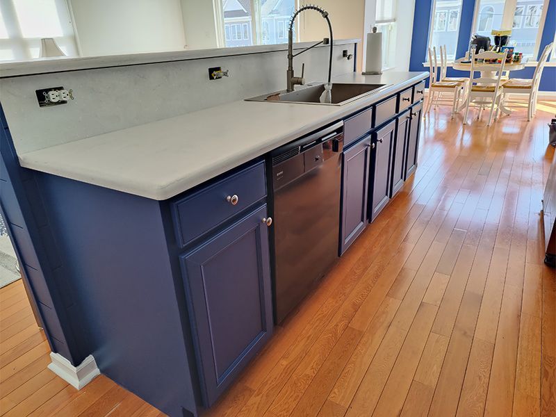 A kitchen with blue cabinets and stainless steel appliances