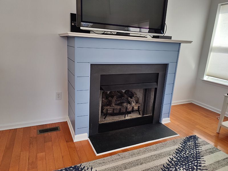 A living room with a fireplace and a flat screen tv.