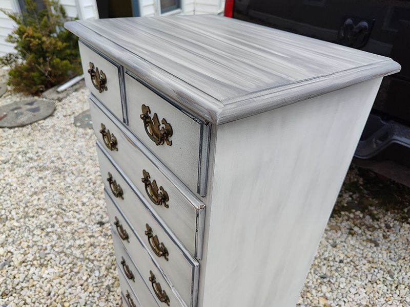 A white chest of drawers with a wooden top