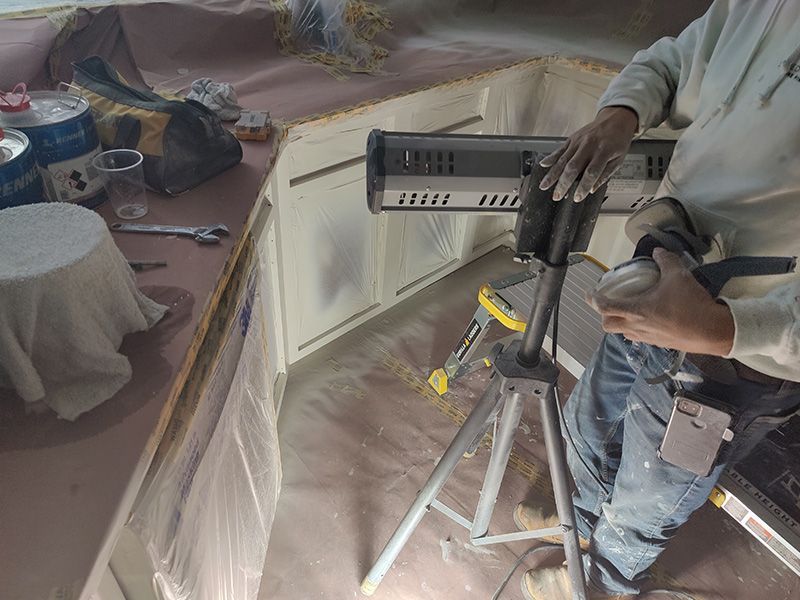 A man is standing in a kitchen with a light on a tripod.