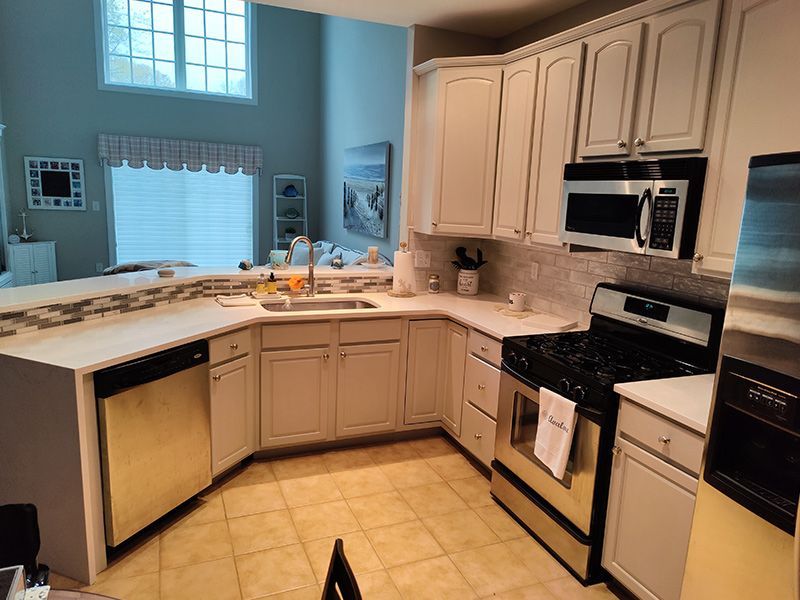 A kitchen with white cabinets and stainless steel appliances