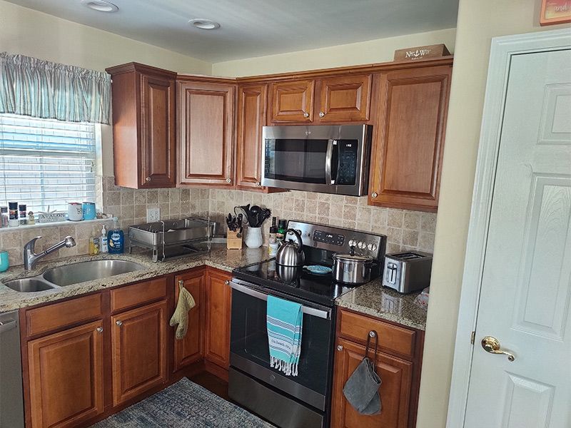 A kitchen with stainless steel appliances and wooden cabinets.