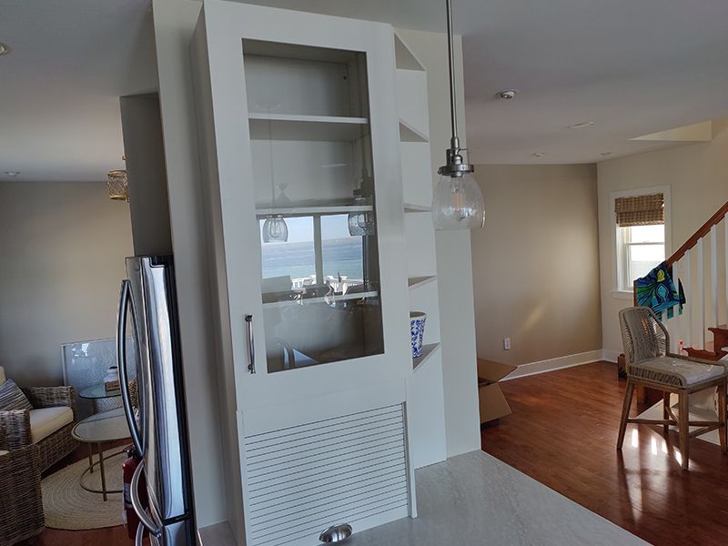 A kitchen with a refrigerator and a glass cabinet