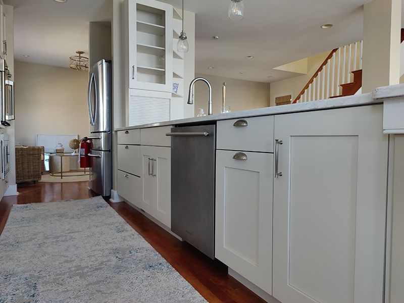 A kitchen with white cabinets and a stainless steel dishwasher