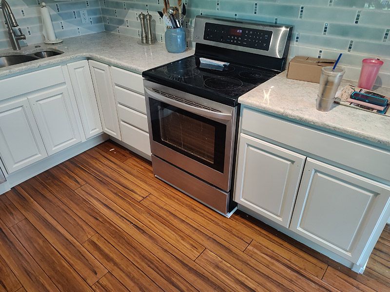 A kitchen with stainless steel appliances and white cabinets.