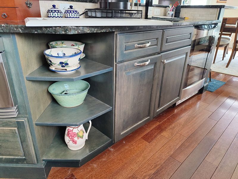 A kitchen with stainless steel cabinets and wooden floors