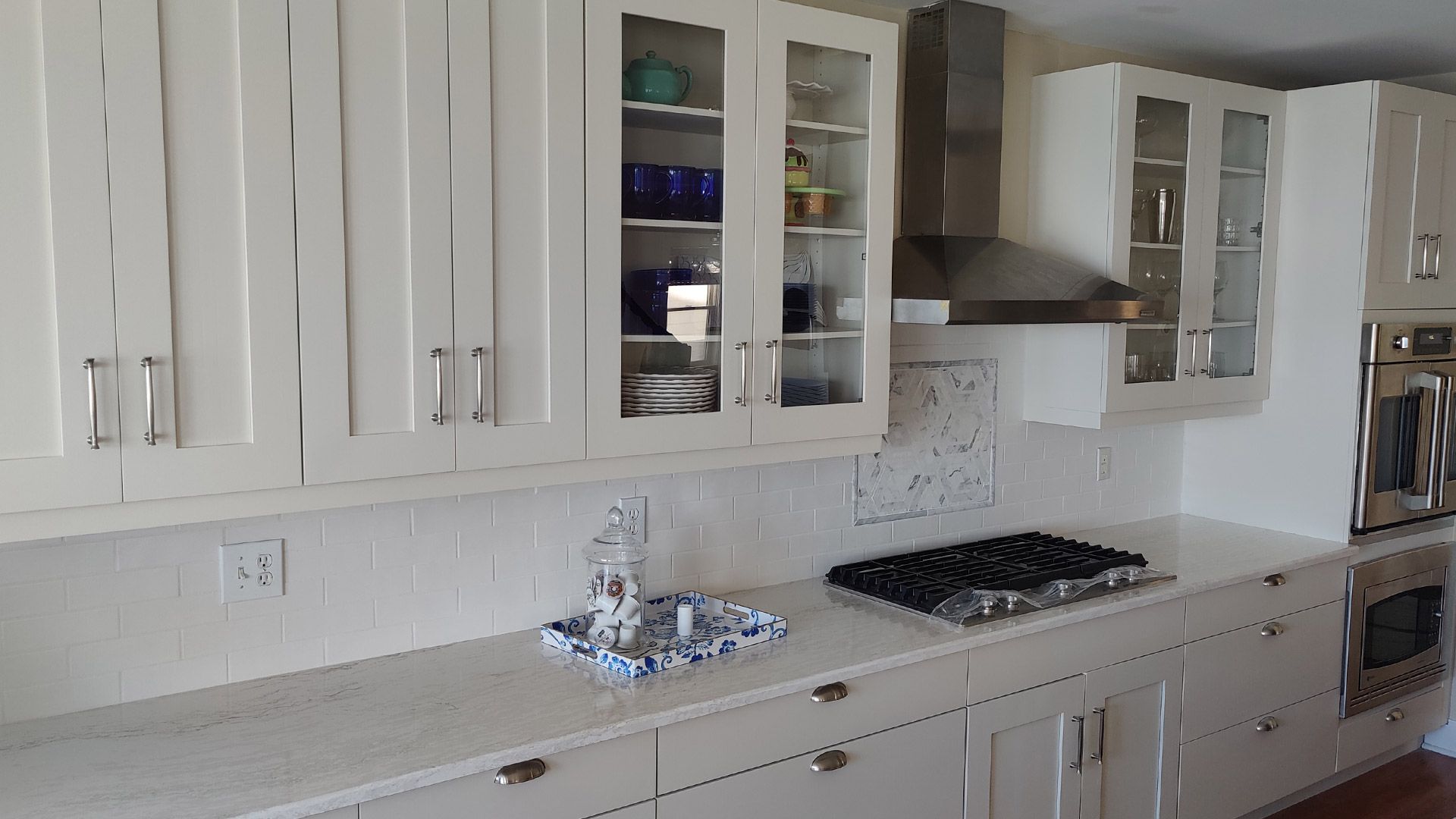 A kitchen with white cabinets and a stove top oven