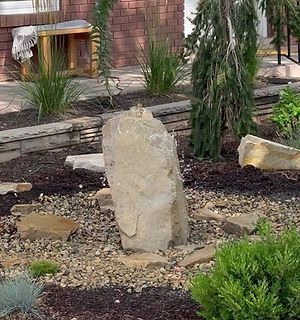 There is a large rock in the middle of the garden.