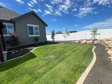A house with a large lawn in front of it and a white fence.