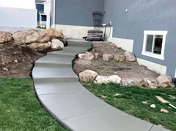 A curved concrete walkway leading to a house.
