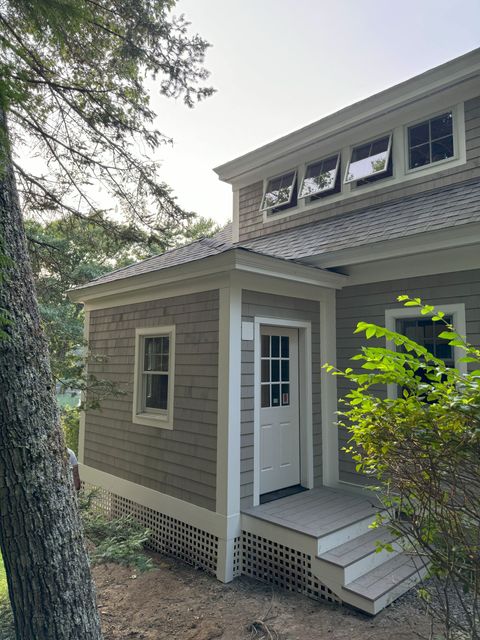 The front door of a house with a wooden door and windows