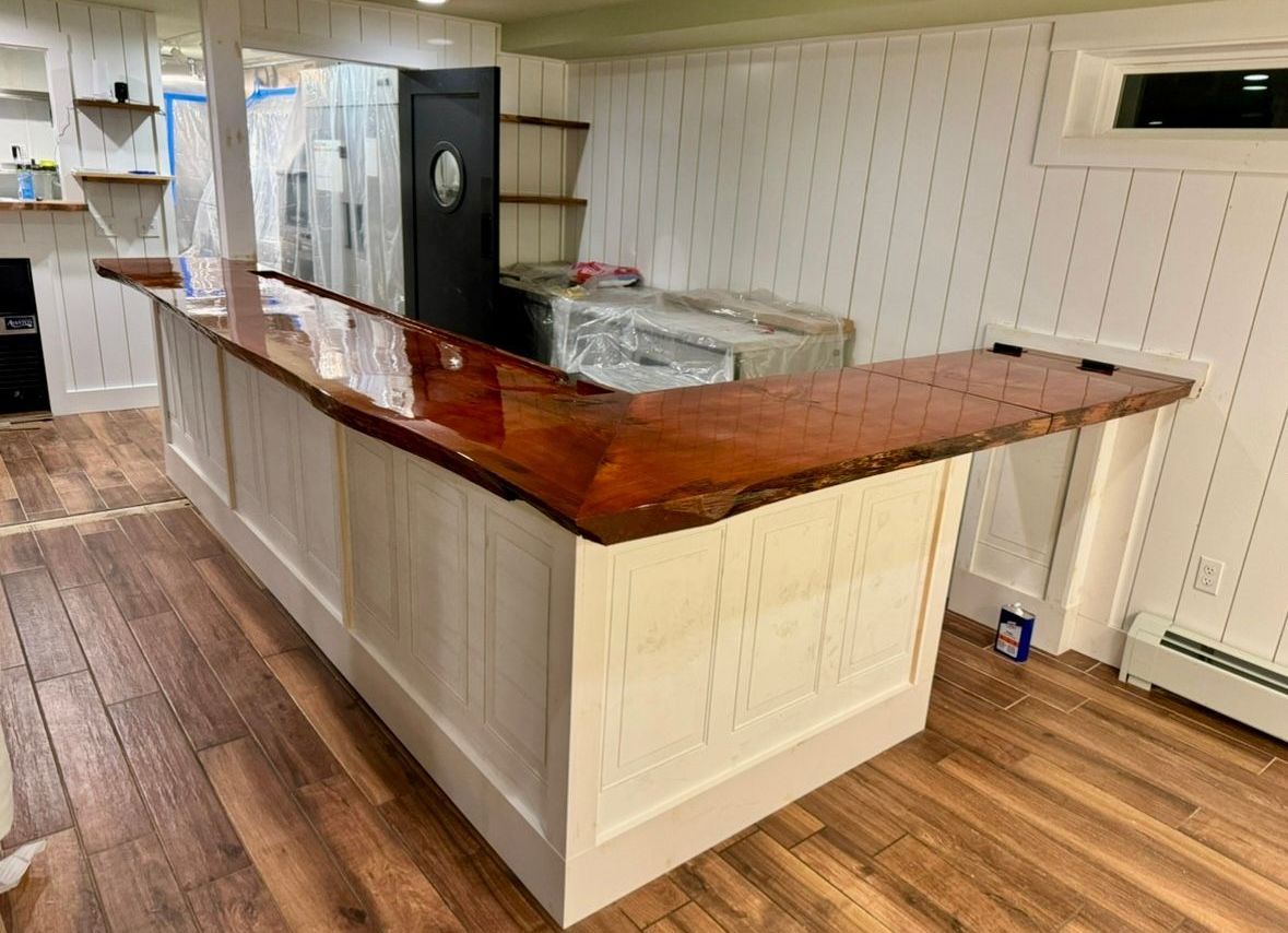 A kitchen with white cabinets , a table and chairs , a sink , and a refrigerator.