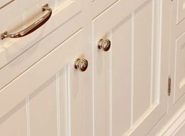 A close up of a white cabinet with chrome handles.