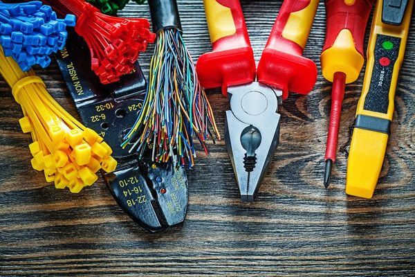 A bunch of electric tools are sitting on a wooden table.