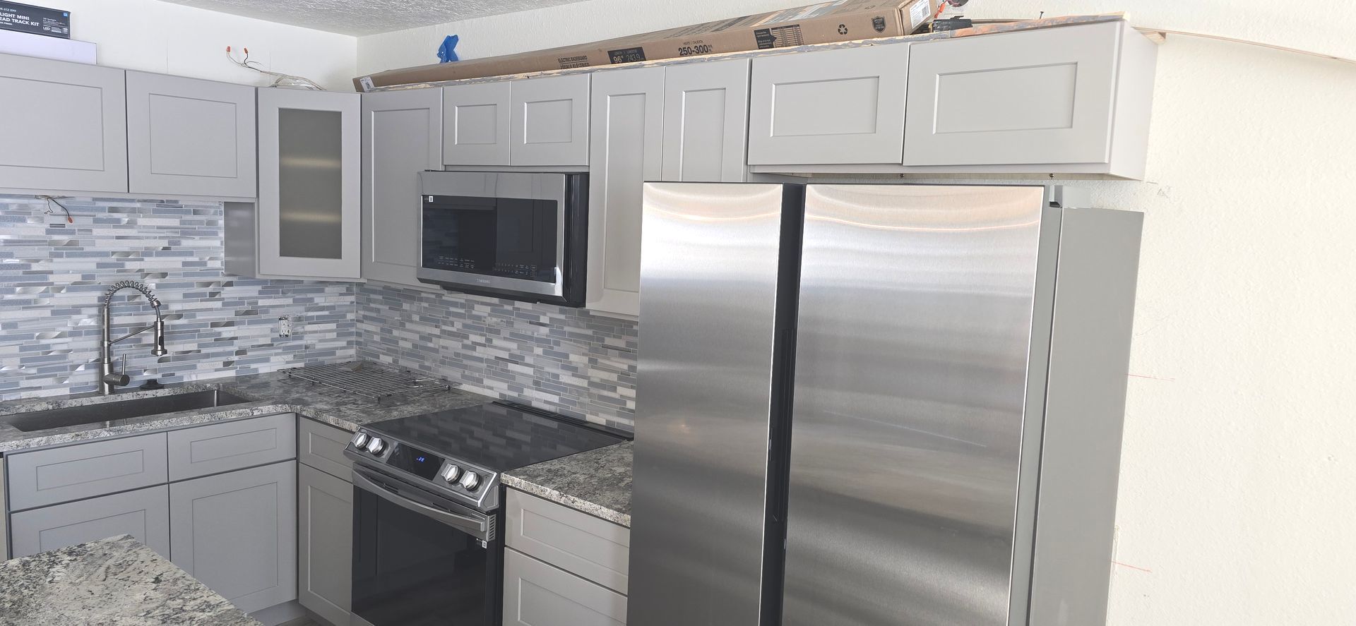 Kitchen with new cabinets, granite countertops all in grey and white