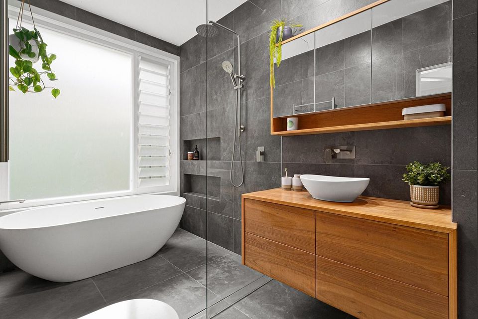 A bathroom with a bathtub , sink , toilet and shower.