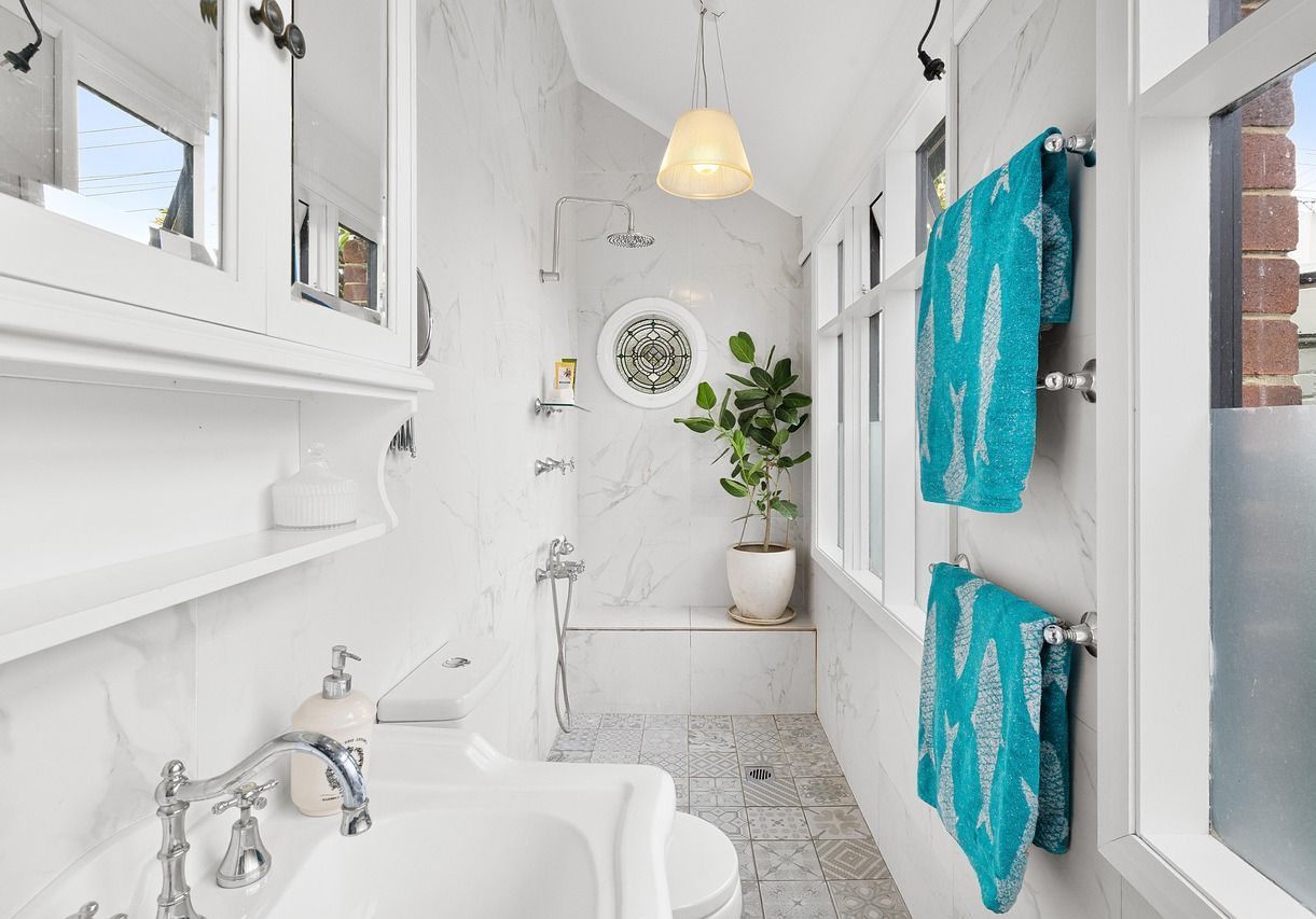 Renovated bathroom with a sink a toilet and a window