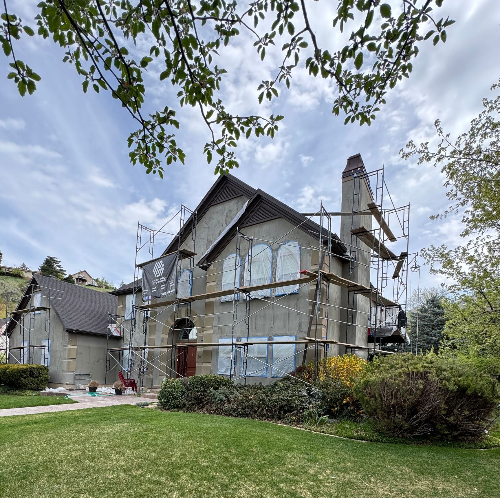 A house is being painted with scaffolding around it