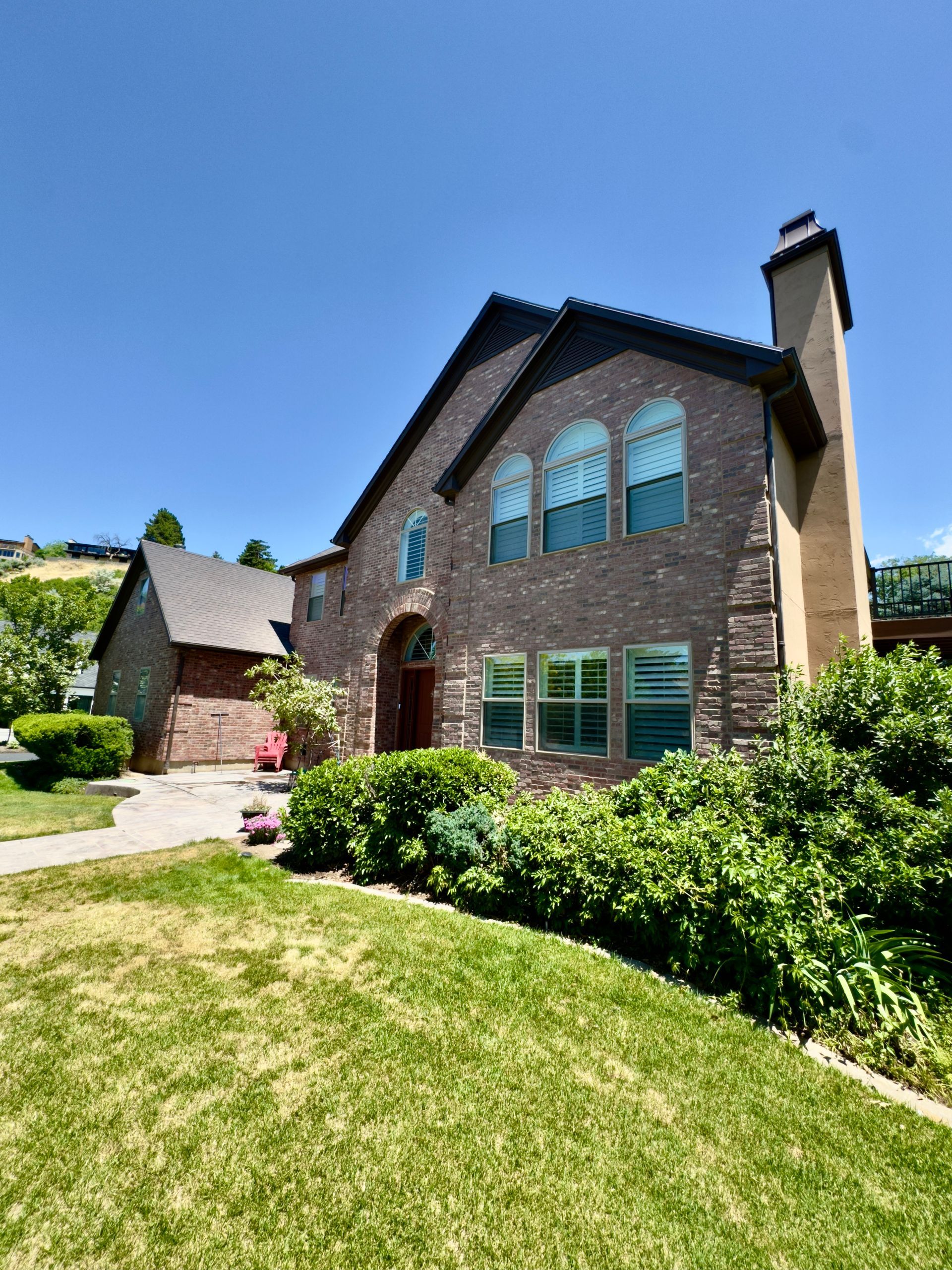 A large brick house with a lot of windows and a chimney