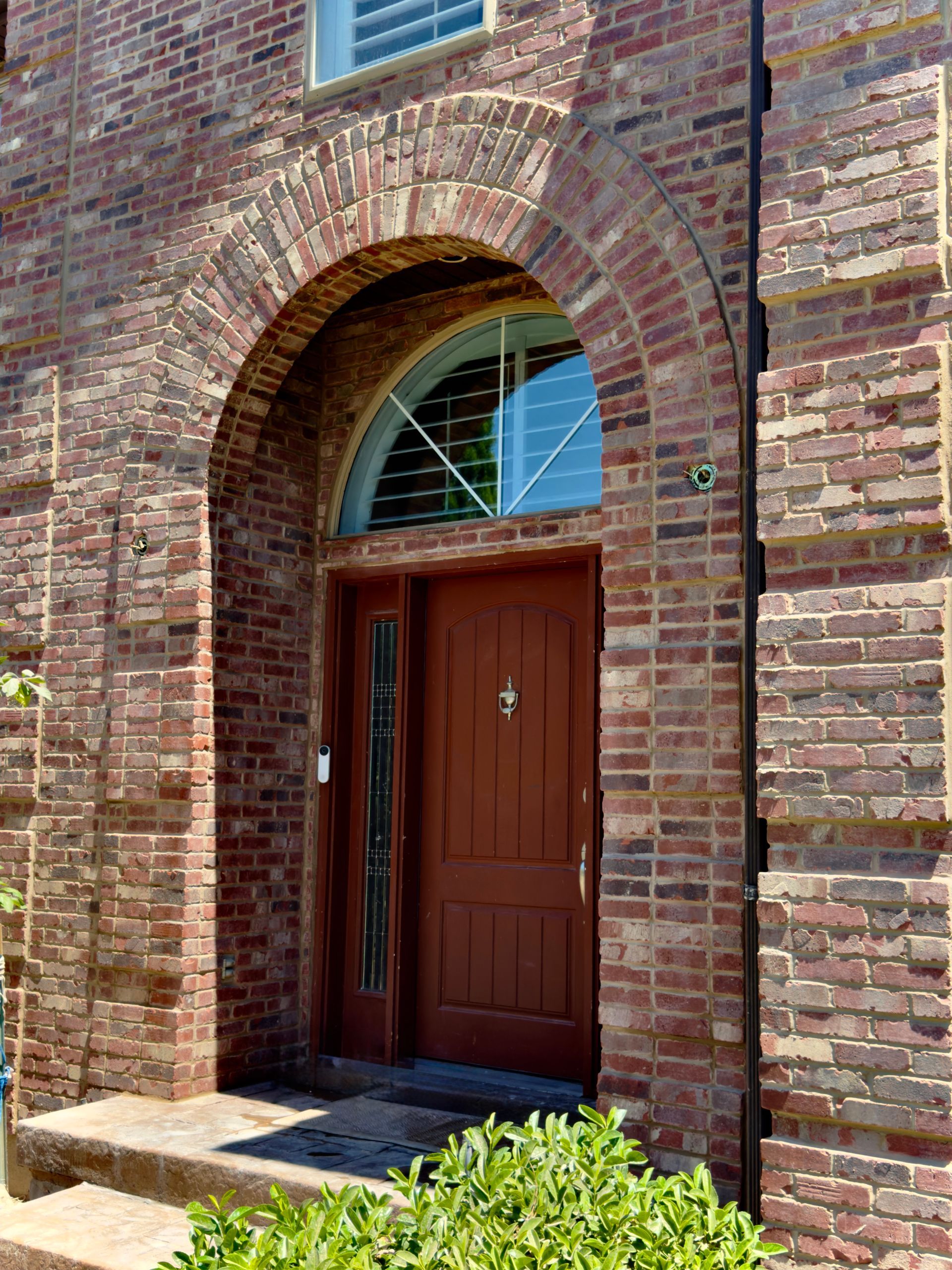A brick building with a red door and a window