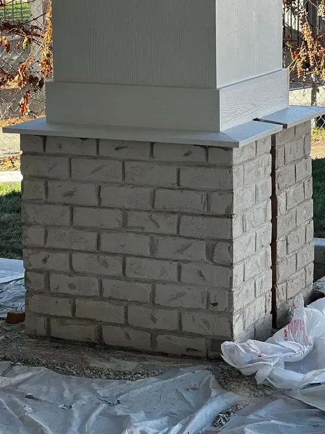 A white brick column is sitting on top of a white tarp.