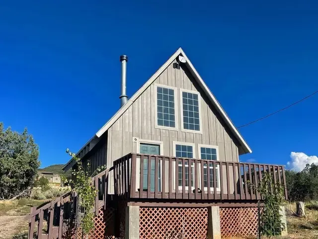 A small house with a deck and a chimney on top of it