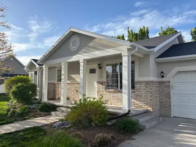 The front of a house with a porch and a garage.