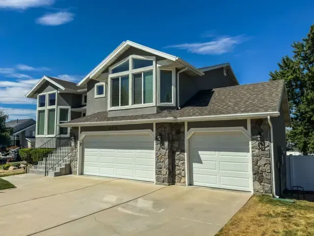 A large house with two garage doors and a large driveway.
