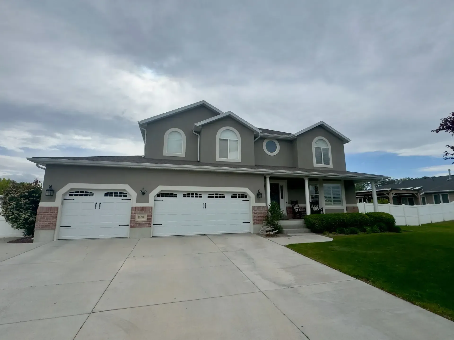 A large house with three garage doors and a driveway.